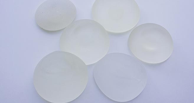 A variety of breast implant options sit on a table.